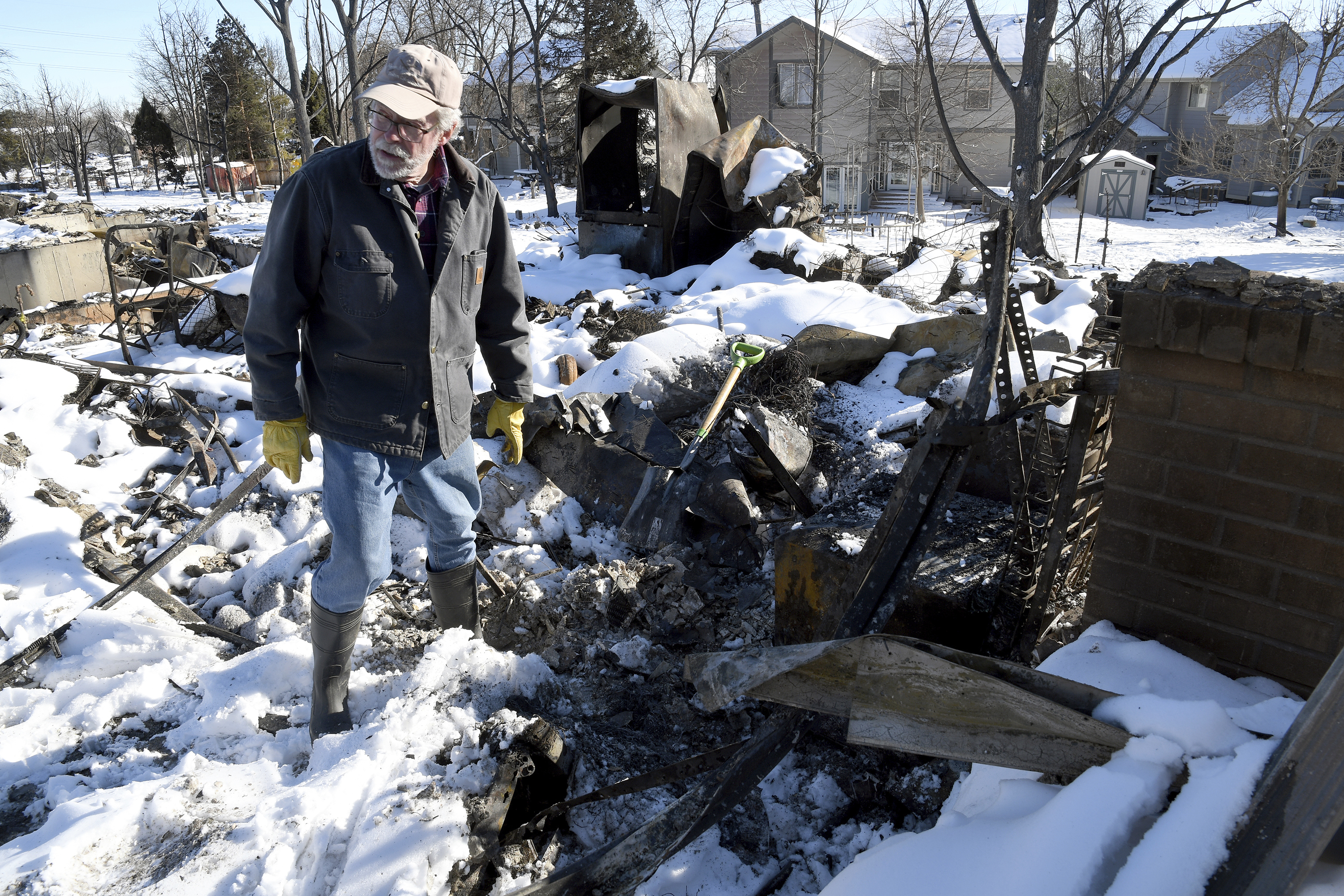 Rex Hickman sifts through the rubble of his burned home in Louisville, Colo., on Jan. 2. Hickman, who had lived in the home with his wife for 23 years, found his safe, but little could be salvaged other than a few gold and silver coins.