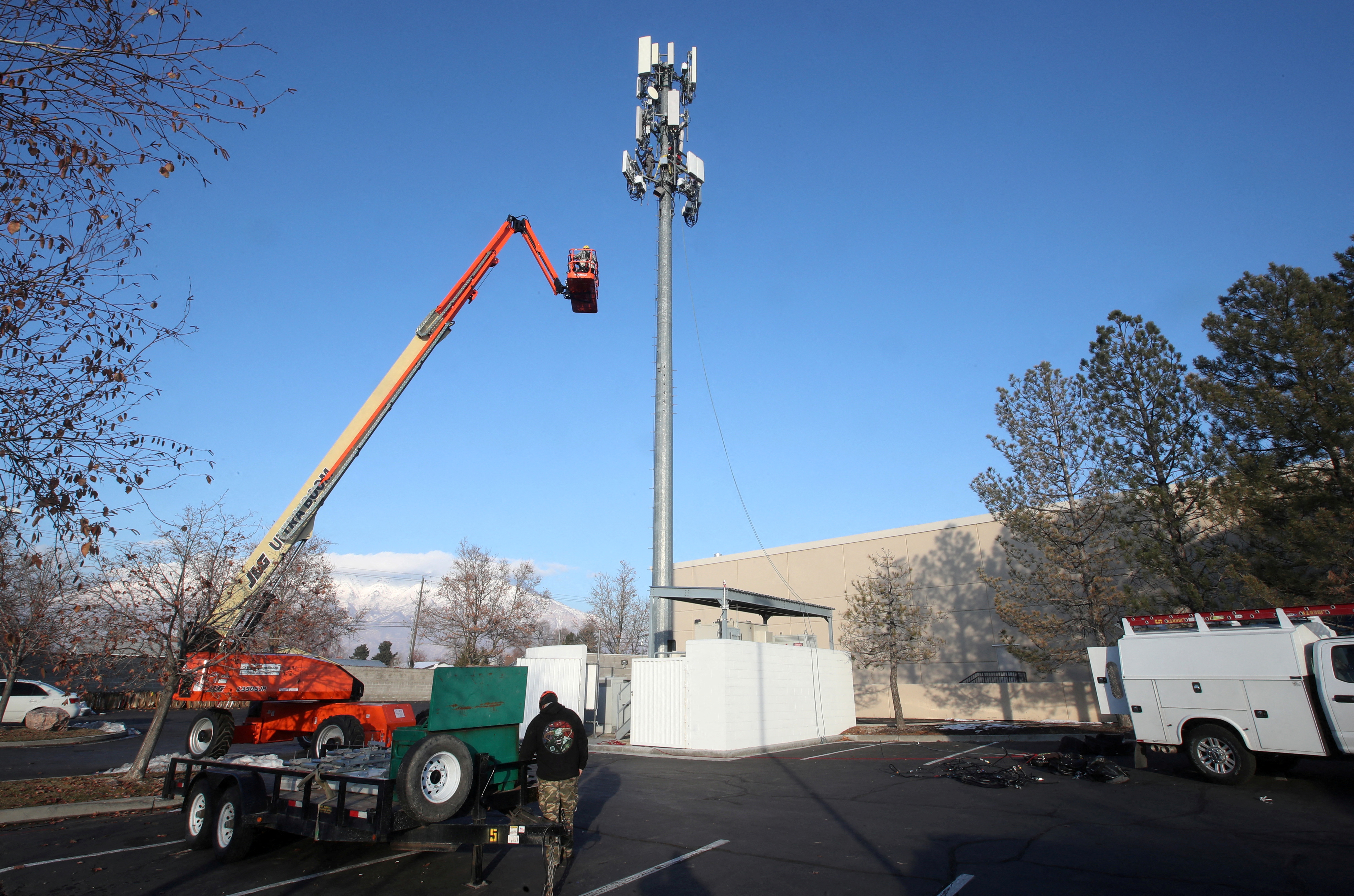 A contract crew from Verizon installs 5G telecommunications equipment on a tower in Orem, Dec. 3, 2019.