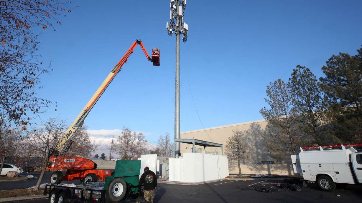 A contract crew from Verizon installs 5G telecommunications equipment on a tower in Orem, Dec. 3, 2019.
