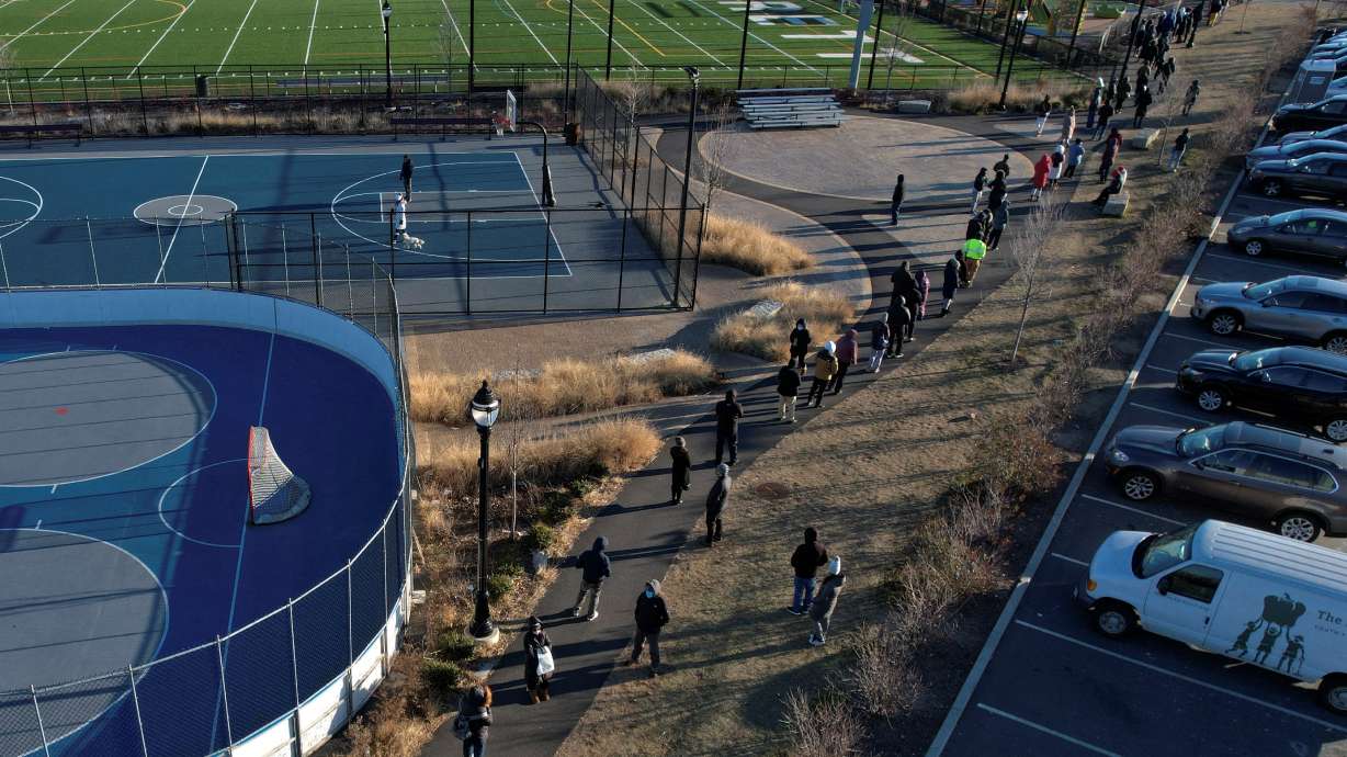 People line up in cold winter temperatures to be tested for the coronavirus in Everett, Massachusetts, Tuesday.