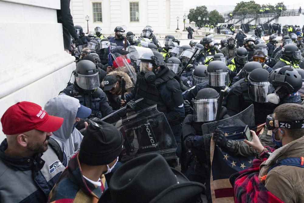 Members of the Washington Metropolitan Police Department help U.S. Capitol Police clear the West Front Senate Plaza of rioters on Wednesday, Jan. 6, 2021, in Washington.
