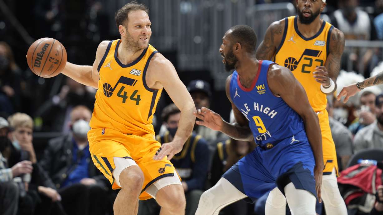 Utah Jazz forward Bojan Bogdanovic, left, looks to pass the ball as Denver Nuggets guard Davon Reed defends in the first half of an NBA basketball game Wednesday, Jan. 5, 2022, in Denver.