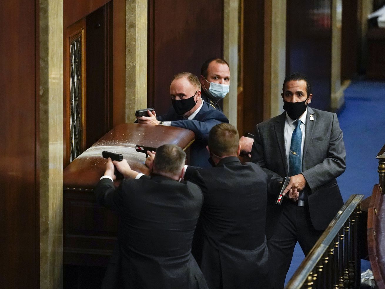 U.S. Capitol Police with guns drawn stand near a barricaded door as rioters try to break into the House Chamber at the U.S. Capitol on Jan. 6, 2021, in Washington. Thursday marked the one-year anniversary of the Capitol riots.
