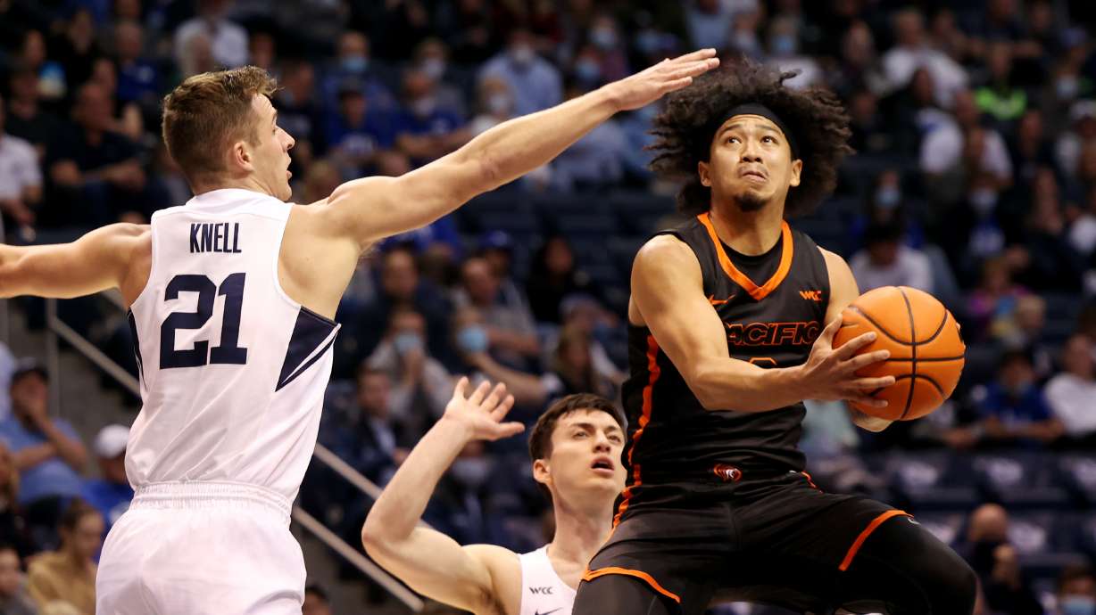 Pacific Tigers guard Pierre Crockrell II (3) flies up for a shot with Brigham Young Cougars guard Trevin Knell (21) trying to defend as BYU and Pacific play in an NCAA basketball game in Provo at the Marriott Center on Thursday, Jan. 6, 2022.