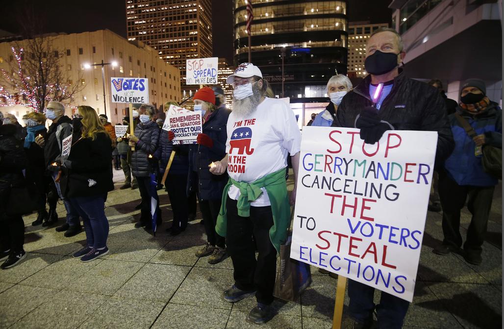 Citizens hold signs at a vigil held in Salt Lake City on Thursday remembering the U.S. Capitol attack on Jan. 6, 2021.