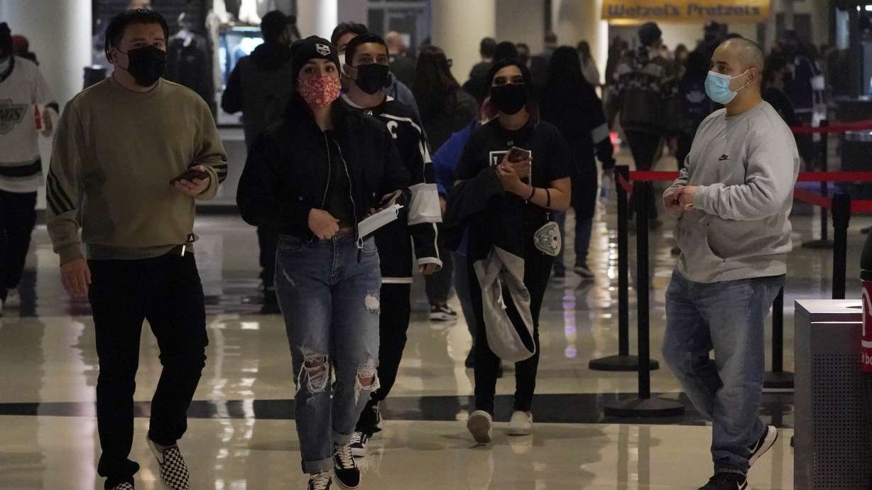 Fans wear masks as they walk inside crypto.com Arena before an NHL hockey game between the Los Angeles Kings and the Nashville Predators Thursday, in Los Angeles.