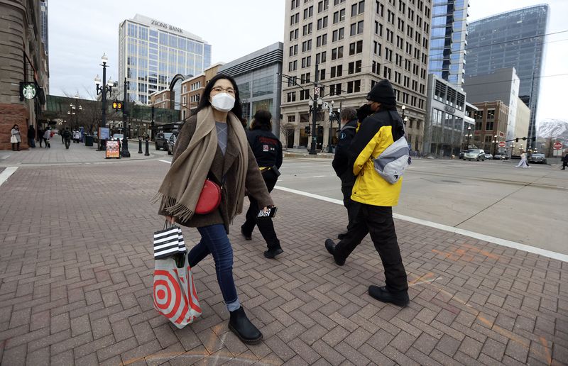 Eunjin Lee wears a mask while walking through downtown
Salt Lake City on Friday, Jan. 7, 2022. A mask mandate goes into
effect for Salt Lake County on Jan. 8 in response to a surge in
omicron COVID-19 cases.
