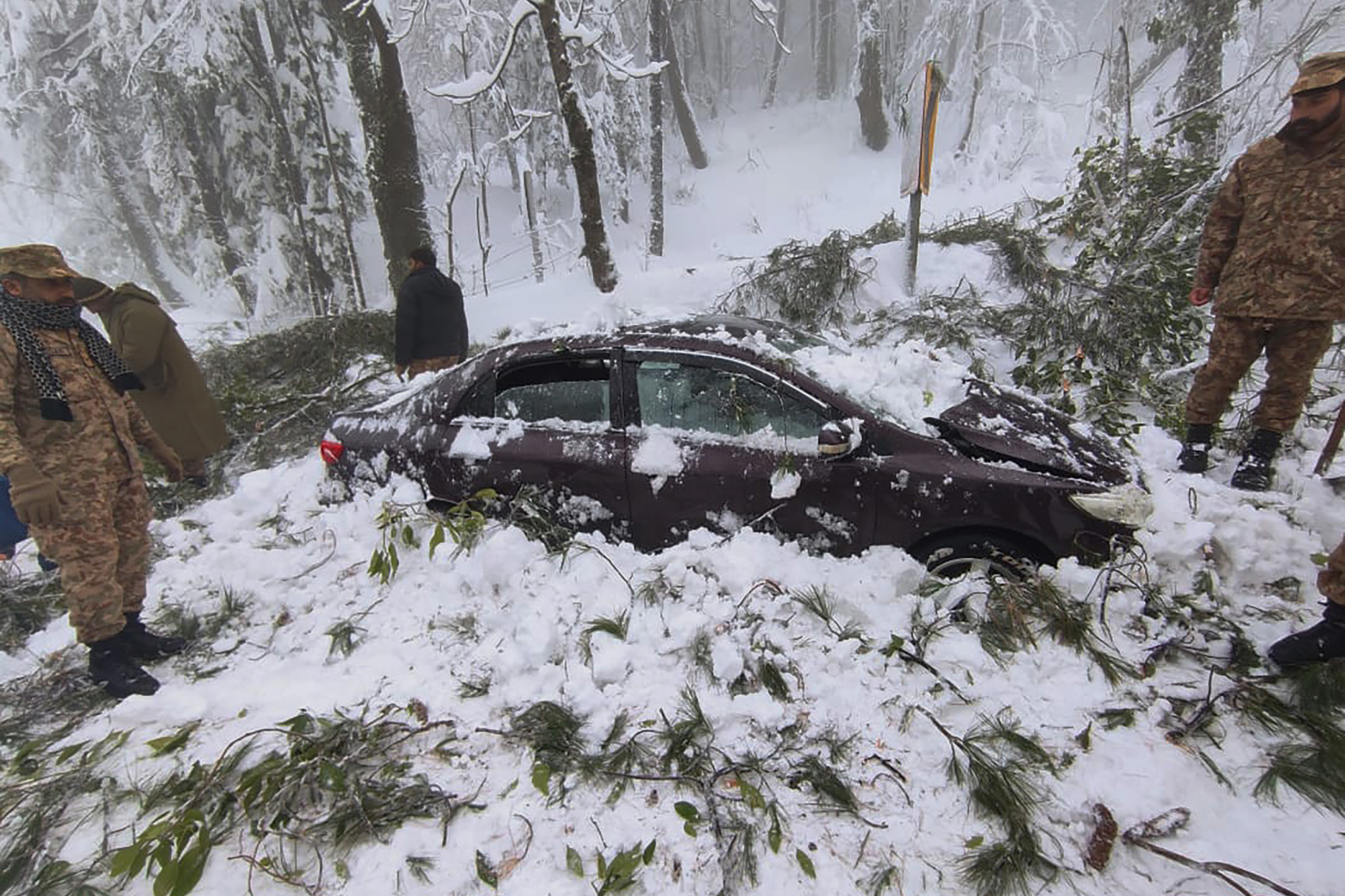 In this photo provided by the Inter Services Public Relations, army troops take part in rescue operation in a heavy snowfall-hit area in Murree, some 28 miles (45 kilometers) north of the capital of Islamabad, Pakistan, Saturday. Temperatures fell to -8 degrees Celsius (17.6 Fahrenheit) amid heavy snowfall at Pakistan's mountain resort town of Murree overnight, killing multiple people who were stuck in their vehicles, officials said Saturday. 