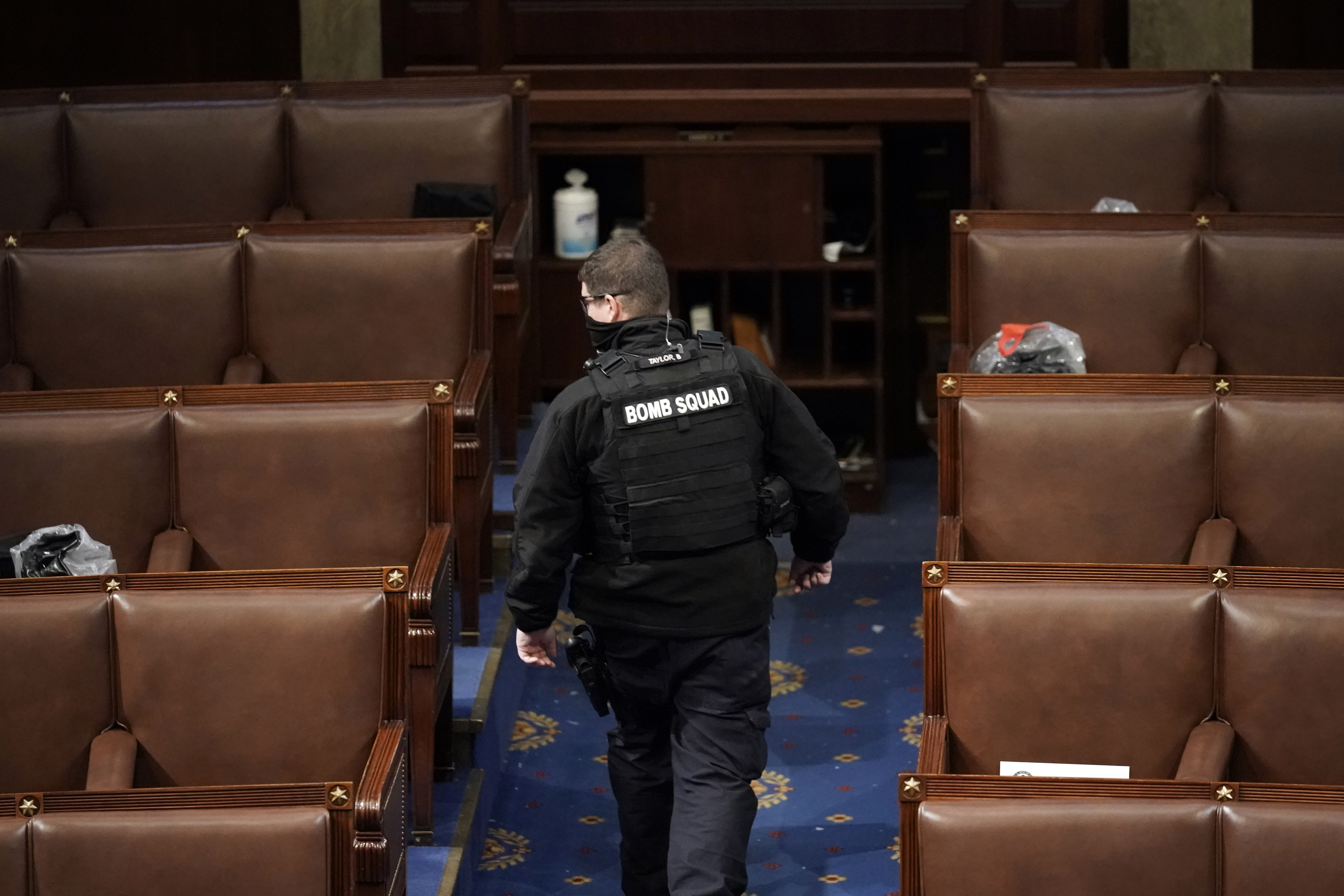 A member of the bomb squad walks on the House floor after rioters who support President Donald Trump broke into the U.S. Capitol on Jan. 6, 2021, in Washington.