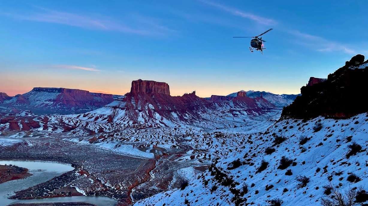 A helicopter assists in the search for a man who died Friday in a BASE jumping accident in Moab.