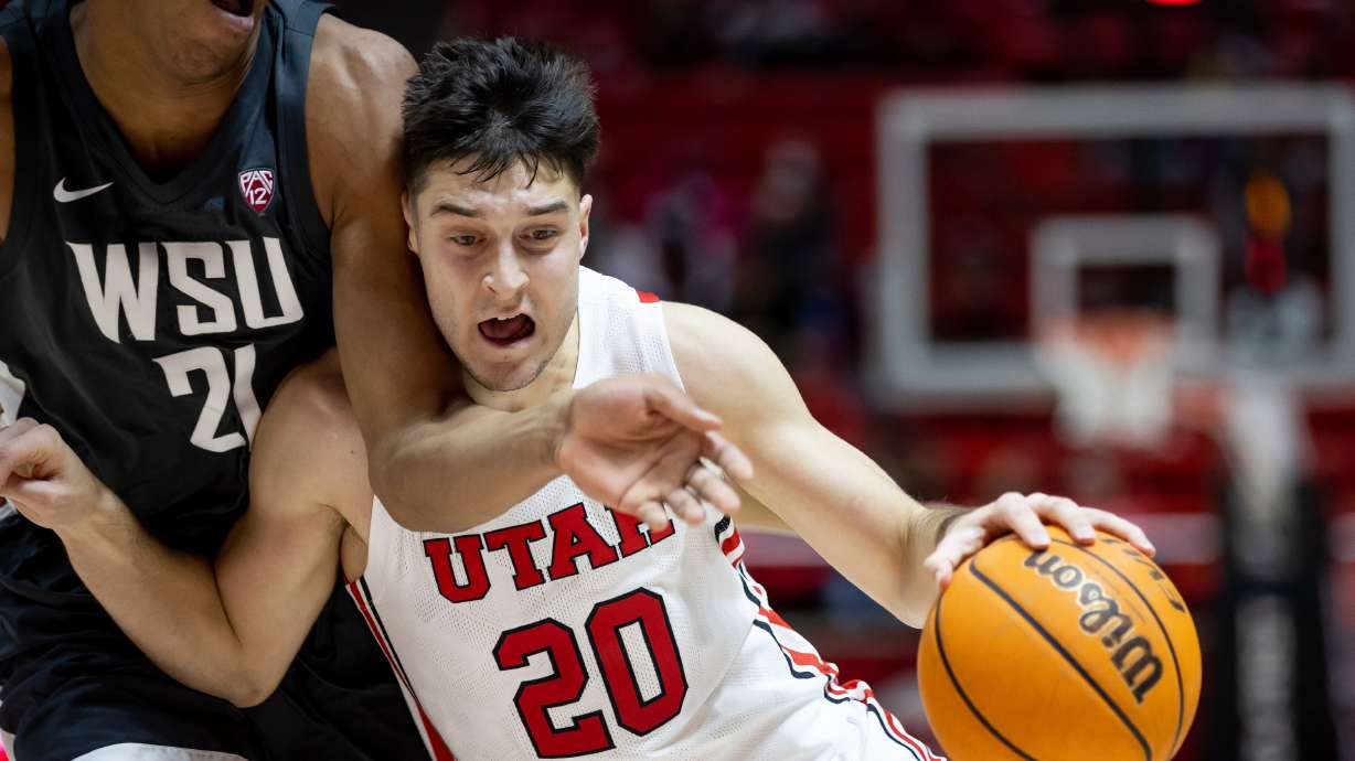 Utah Utes guard Lazar Stefanovic (20) drives against Washington State Cougars center Dishon Jackson (21) during the game at the Huntsman Center in Salt Lake City on Saturday, Jan. 8, 2022.