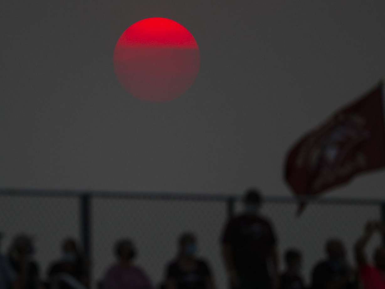 The sun glows orange as it sets over Maple Mountain during a high school football game in Pleasant Grove on Aug. 21, 2020.