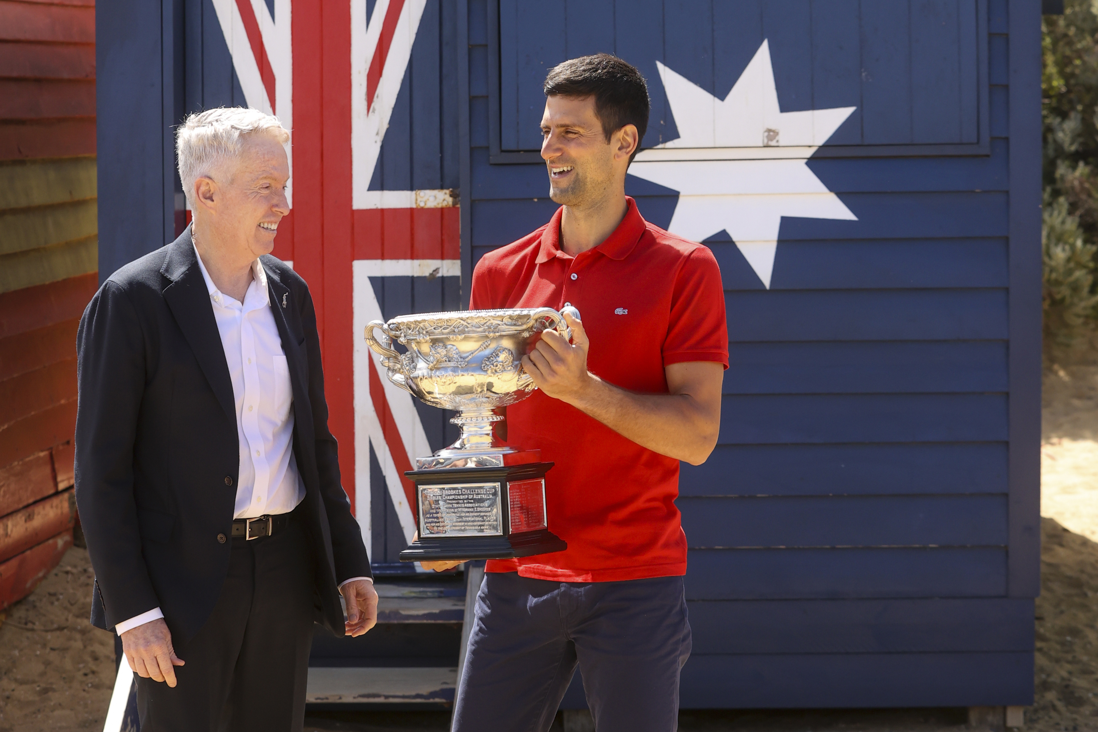 Serbia's Novak Djokovic, right, stands with Australian Open tournament director Craig Tiley following his win the Australian Open tennis championships in Melbourne, Australia, Feb 22, 2021. Monday a judge ruled he could stay in Australia, for now.