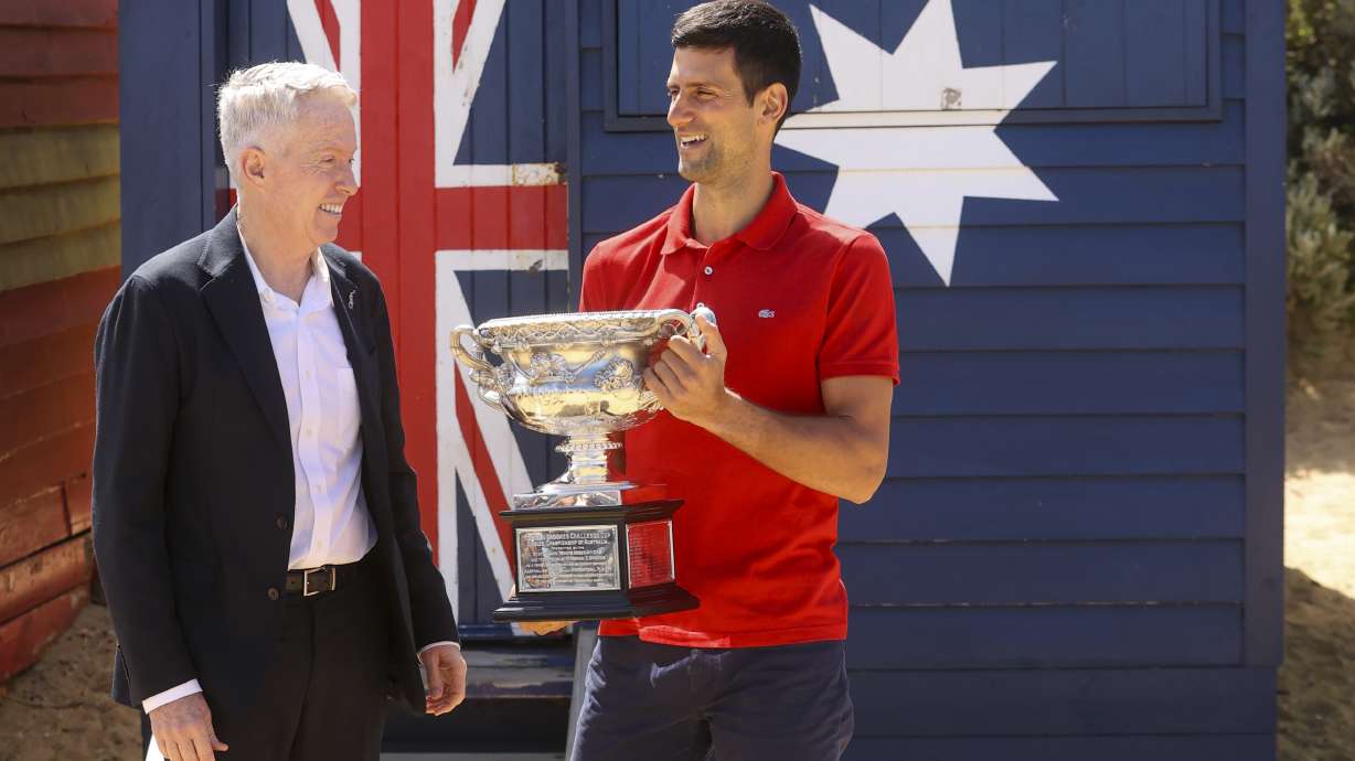 Serbia's Novak Djokovic, right, stands with Australian Open tournament director Craig Tiley following his win the Australian Open tennis championships in Melbourne, Australia, Feb 22, 2021. Monday a judge ruled he could stay in Australia, for now.