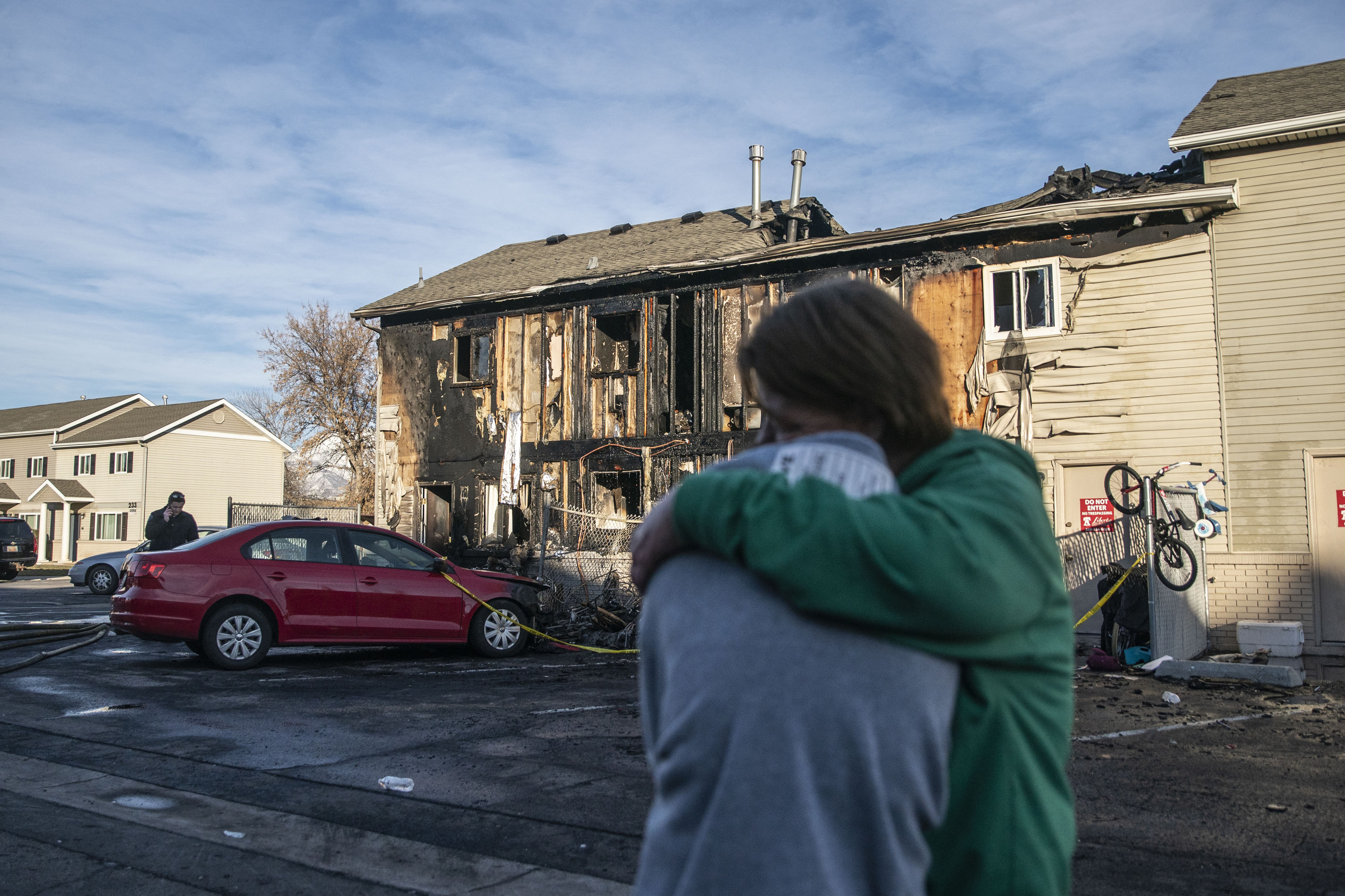 Tara Cooper, right, hugs her daughter in law after the family got displaced due to a fire at an apartment complex in Clearfield on Sunday.