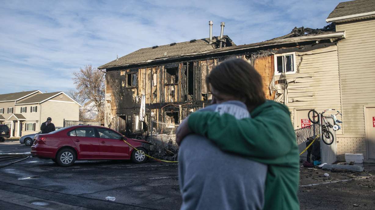 Tara Cooper, right, hugs her daughter in law after the family got displaced due to a fire at an apartment complex in Clearfield on Sunday.