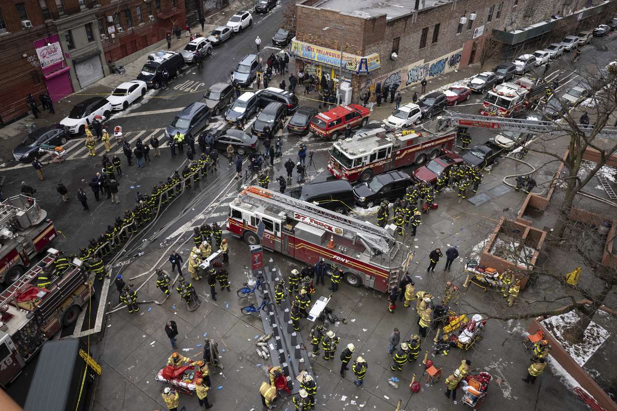 Firefighters work outside an apartment building after a fire in the Bronx, Sunday, in New York.