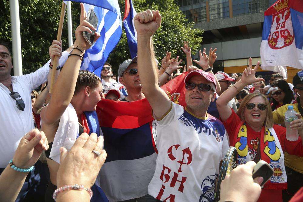 Fans of Serbia's Novak Djokovic react to news of his overturned ruling outside Federal Court ahead of the Australian Open in Melbourne, Australia, Monday.