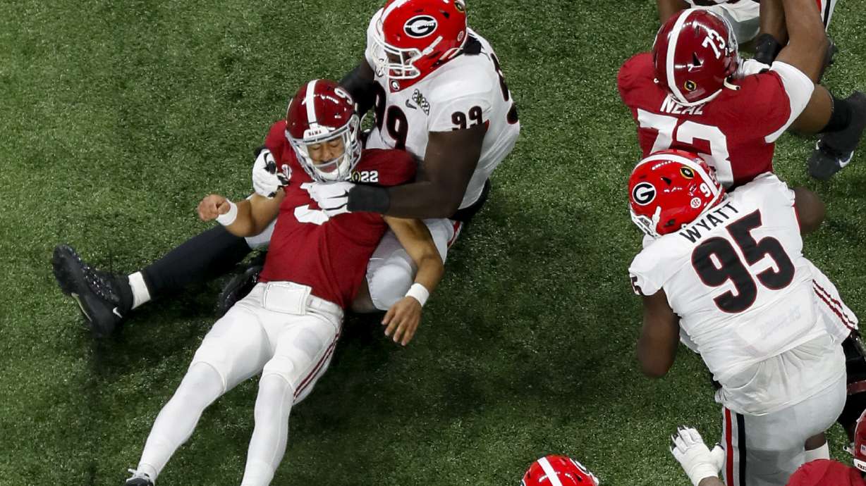 Georgia Bulldogs defensive lineman Jordan Davis (99) strips the ball from Alabama Crimson Tide quarterback Bryce Young (9) in the first quarter. Georgia recovered and appeared to score but it was ruled an incomplete pass at the 2022 College Football Playoff National Championship between the Georgia Bulldogs and the Alabama Crimson Tide at Lucas Oil Stadium in Indianapolis on Monday, January 10, 2022.