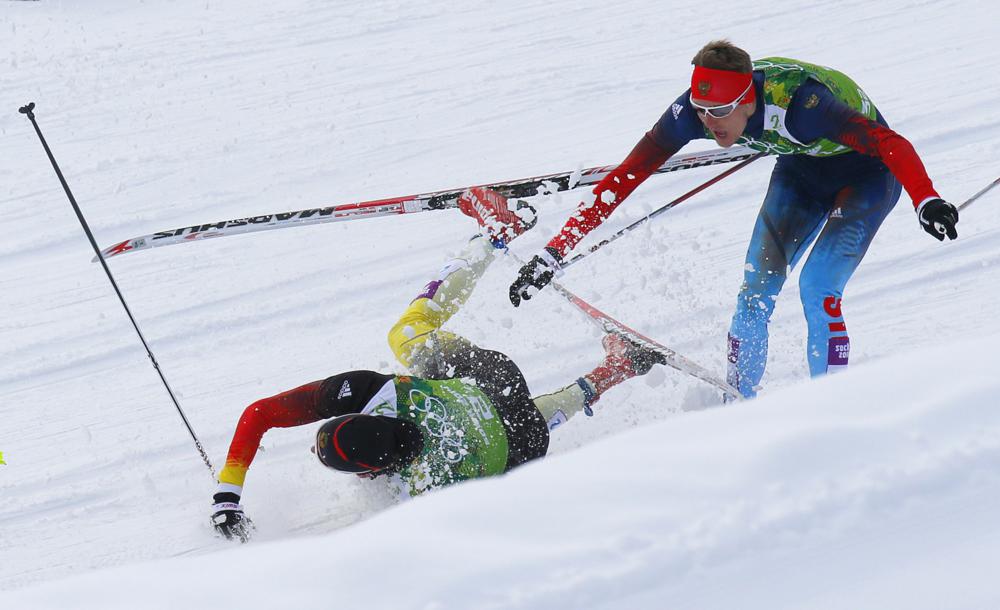 Germany's Tim Tscharnke falls in front of Russia's Nikita Kriukov, right, after making contact with the skis of Finland's Sami Jauhojaervi in the men's classical-style final of the cross-country team sprint competitions at the 2014 Winter Olympics, Feb. 19, 2014, in Krasnaya Polyana, Russia.