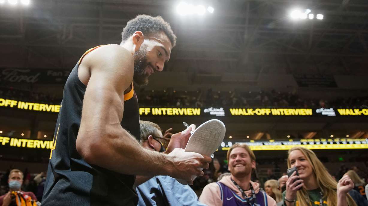 Utah Jazz center Rudy Gobert signs a shoe for a fan after their victory against the Minnesota Timberwolves during an NBA game at Vivint Arena in Salt Lake City on Friday, Dec. 31, 2021.