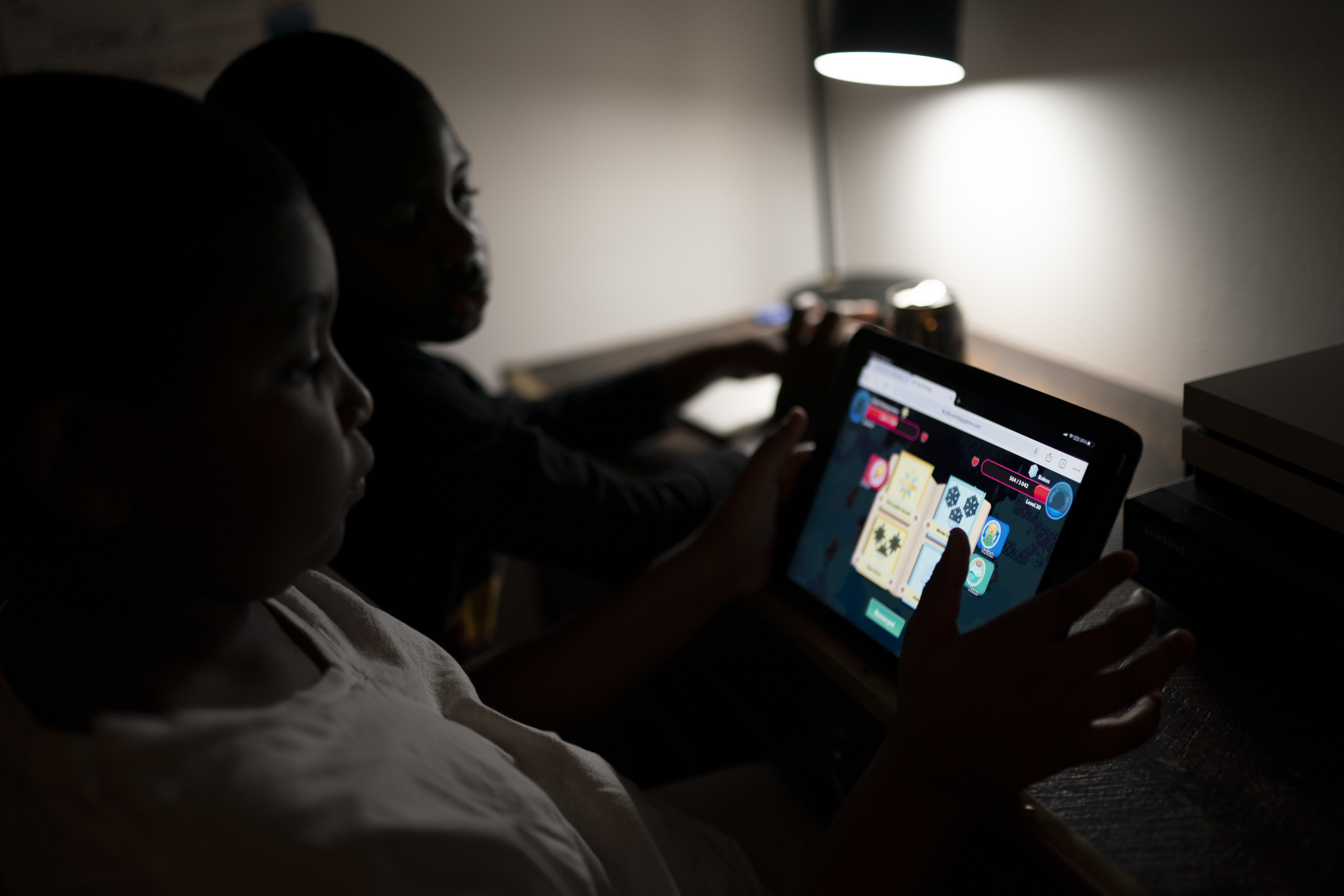 Isaiah Schneider, 9, left, and his brother Adam, 7, complete a level on their learning game played on a tablet computer, in their bedroom, Wednesday, Dec. 8, 2021, in the Brooklyn borough of New York.