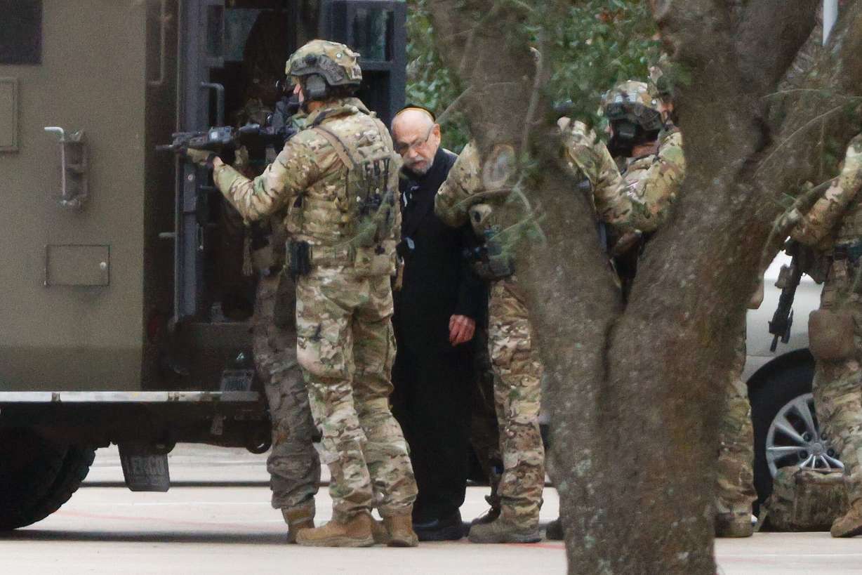 Shortly after 5 p.m., local time, authorities escort a hostage out of the Congregation Beth Israel synagogue in Colleyville, Texas, Saturday. Police said the man was not hurt and would be reunited with his family.