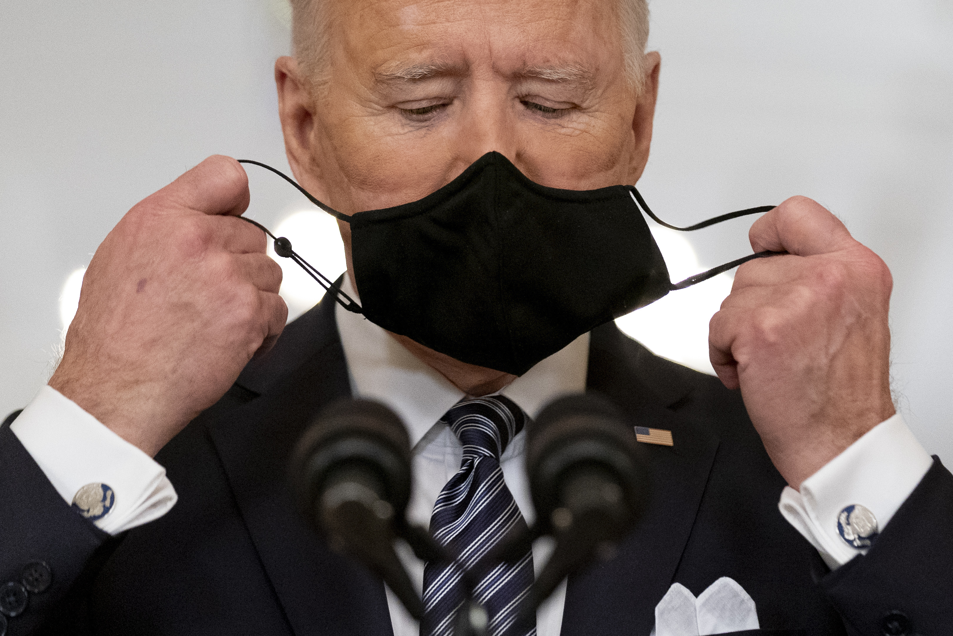 President Joe Biden takes off his mask to speak about the COVID-19 pandemic during a prime-time address from the East Room of the White House, on March 11, 2021, in Washington.