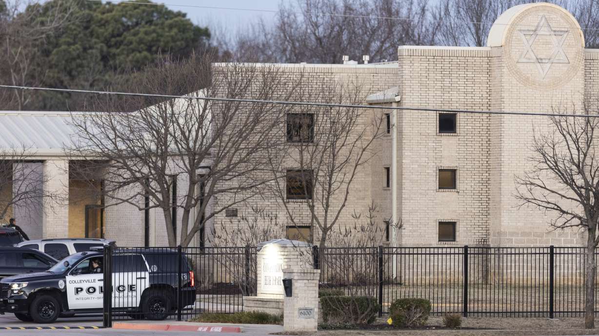 Police stand in front of the Congregation Beth Israel synagogue, Sunday in Colleyville, Texas. A 44-year-old British national held hostages for more than 10 hours Saturday inside the temple.