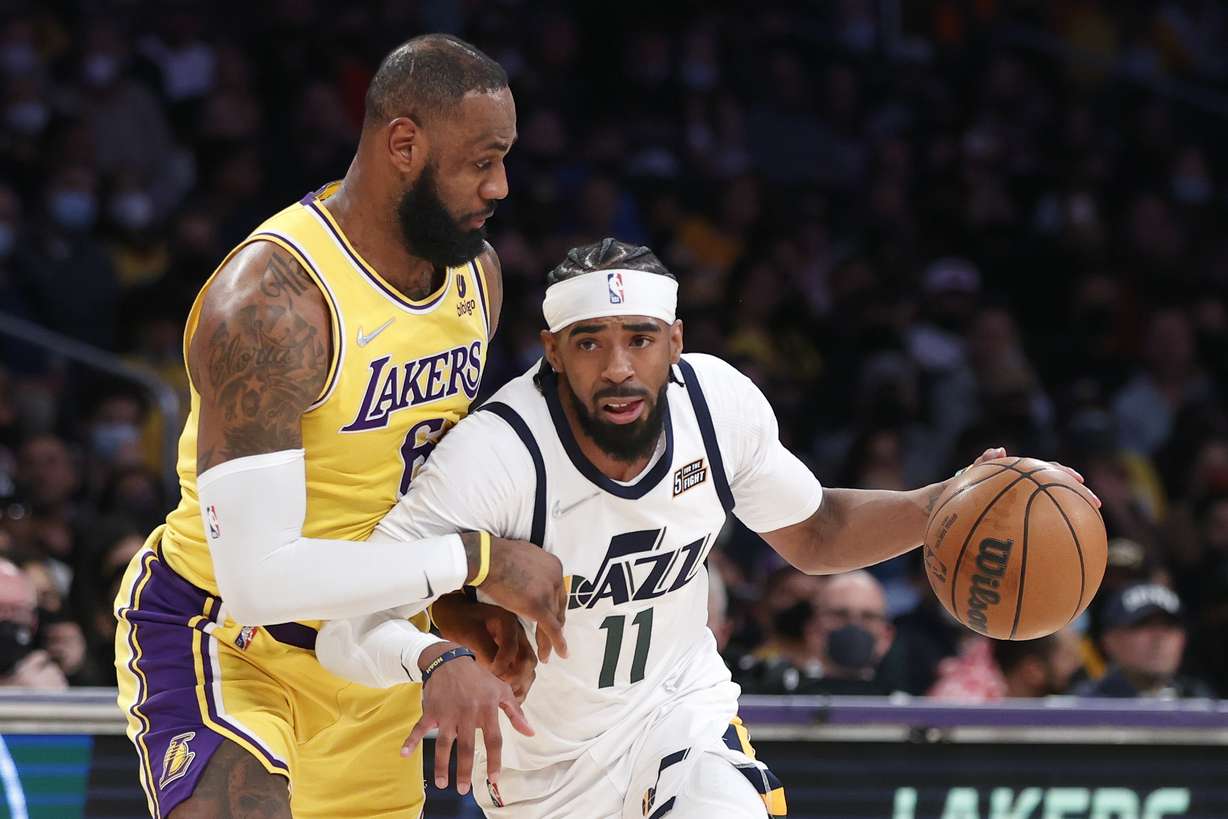 Utah Jazz guard Mike Conley (11) drives past Los Angeles Lakers forward LeBron James (6) during the first half of an NBA basketball game in Los Angeles, Monday, Jan. 17, 2022.