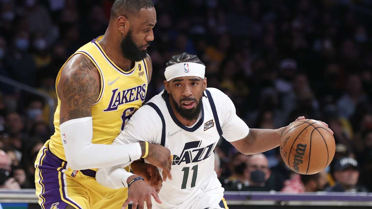 Utah Jazz guard Mike Conley (11) drives past Los Angeles Lakers forward LeBron James (6) during the first half of an NBA basketball game in Los Angeles, Monday, Jan. 17, 2022.