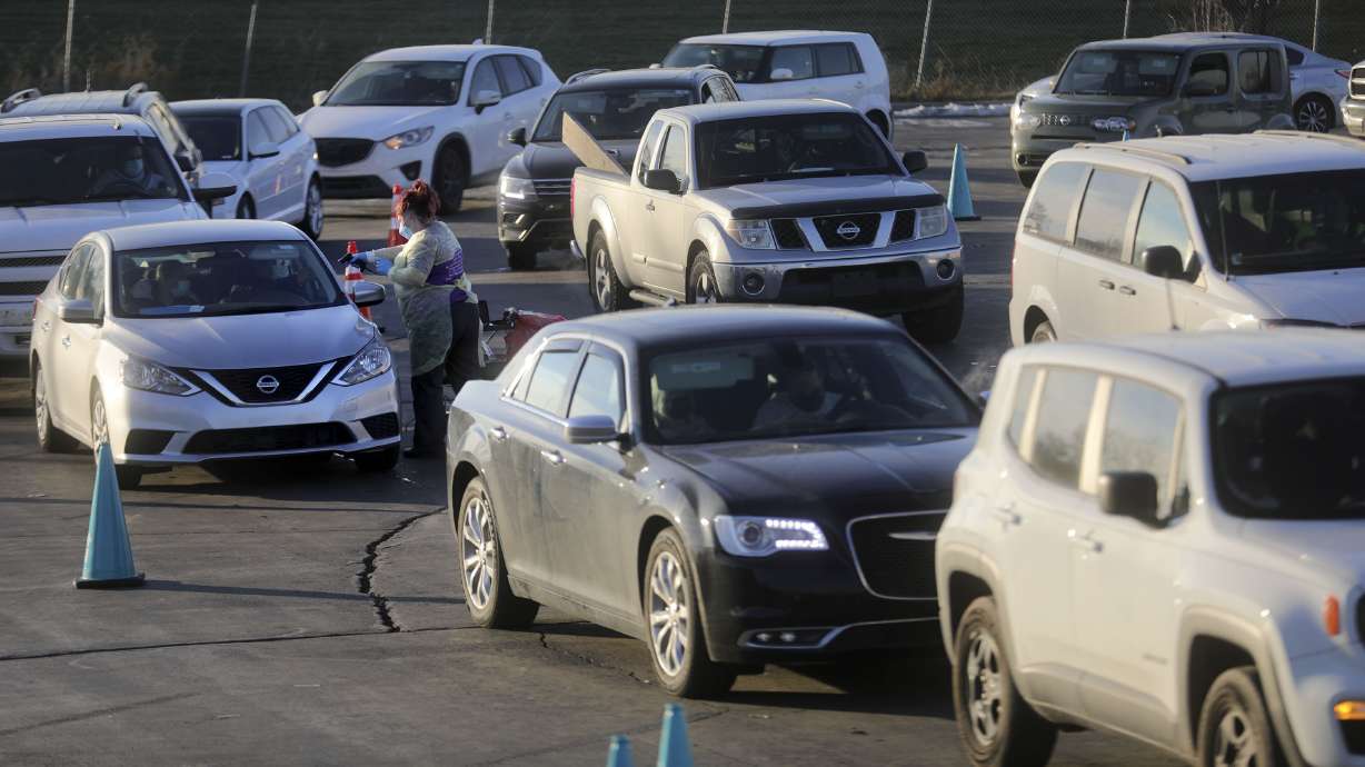 A medical worker checks in vehicles for COVID-19 testing outside of the Maverik Center in West Valley City on Jan. 10. Utah health officials on Tuesday reported 39,882 new COVID-19 cases and 28 deaths over the holiday weekend.