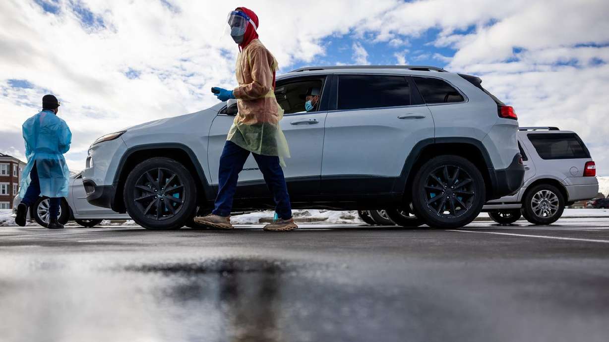 Health care worker Bob Ekoh administers COVID-19 tests at City Hall in Herriman on Jan. 6. COVID-19 daily case counts have dipped, but questions about the numbers' accuracy remain.