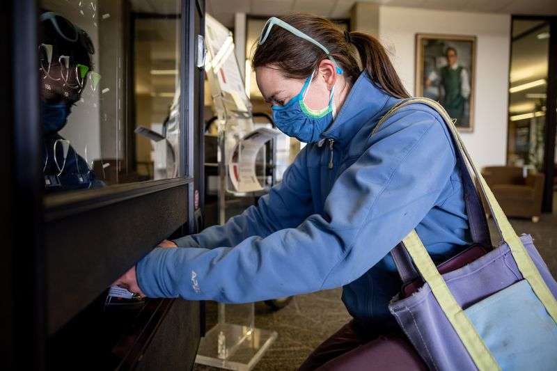 Rebecca Zitnay, a graduate student working at the
Huntsman Cancer Institute, picks up a self-administered COVID-19
test from a vending machine at the Eccles Health Sciences Library
on the University of Utah campus in Salt Lake City on Tuesday.