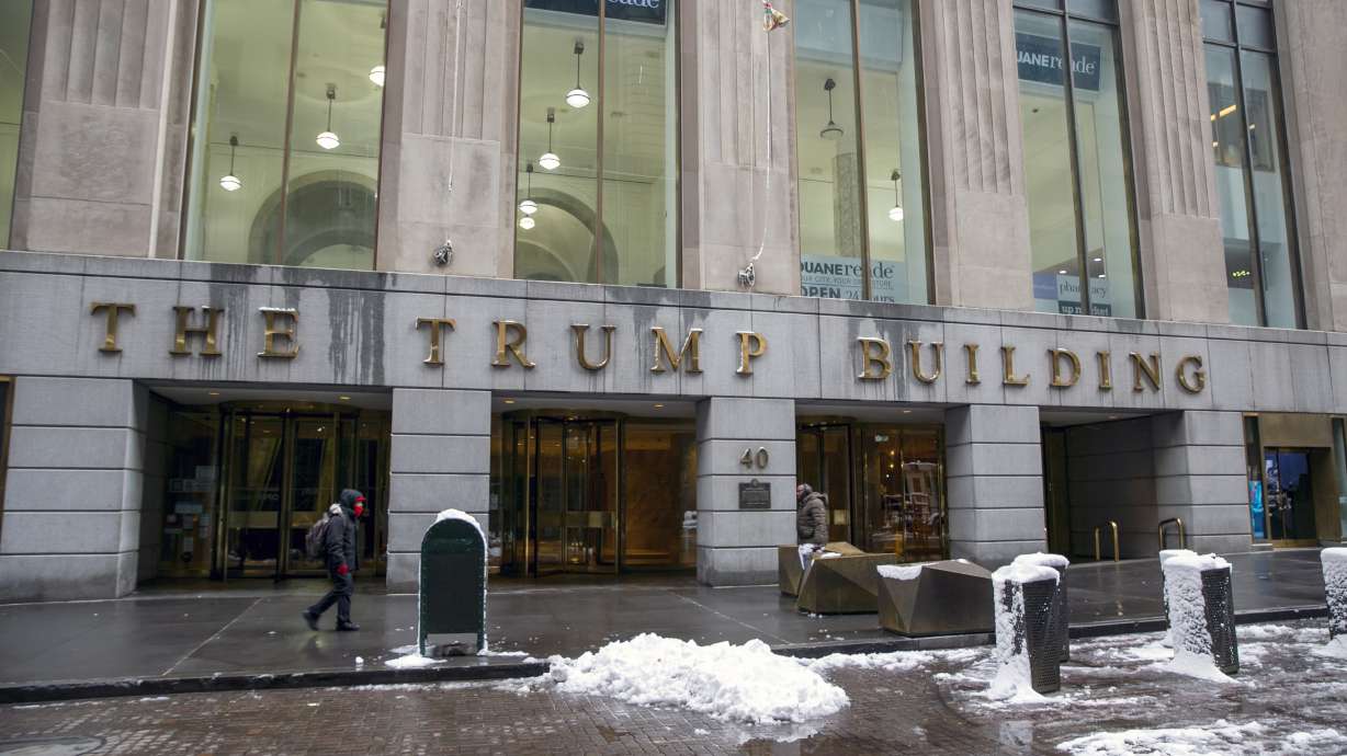 People walk by The Trump Building office building at 40 Wall Street in New York on Jan. 7. The New York attorney general’s office says Tuesday its civil investigation has uncovered evidence that former President Donald Trump's company used “fraudulent or misleading” asset valuations to get loans and tax benefits.