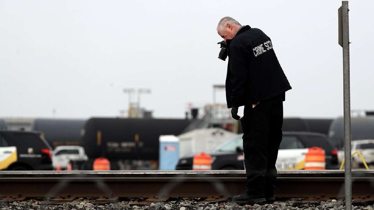 A crime scene investigator takes photos after a Union Pacific Railroad train hit and killed a person in the area of 2700 West and 500 South in Salt Lake City on Wednesday.