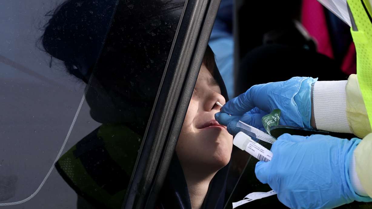 A child is tested for COVID-19 in Bountiful on Wednesday. The Utah Department of Health reported 11,608 new cases of COVID-19 on Thursday and 22 deaths, bringing the total number of coronavirus-related deaths to 4,019.