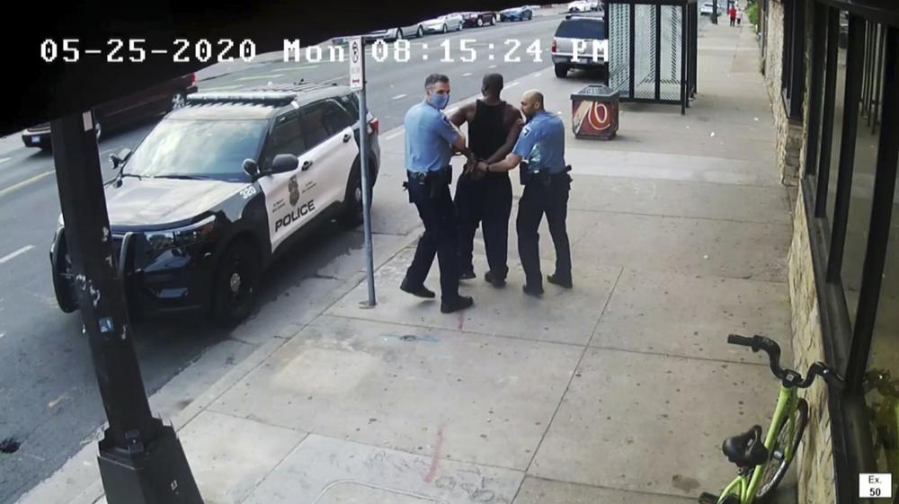 This image from video shows Minneapolis police Officers Thomas Lane, left and J. Alexander Kueng, right, escorting George Floyd, center, to a police vehicle outside Cup Foods in Minneapolis, on May 25, 2020.