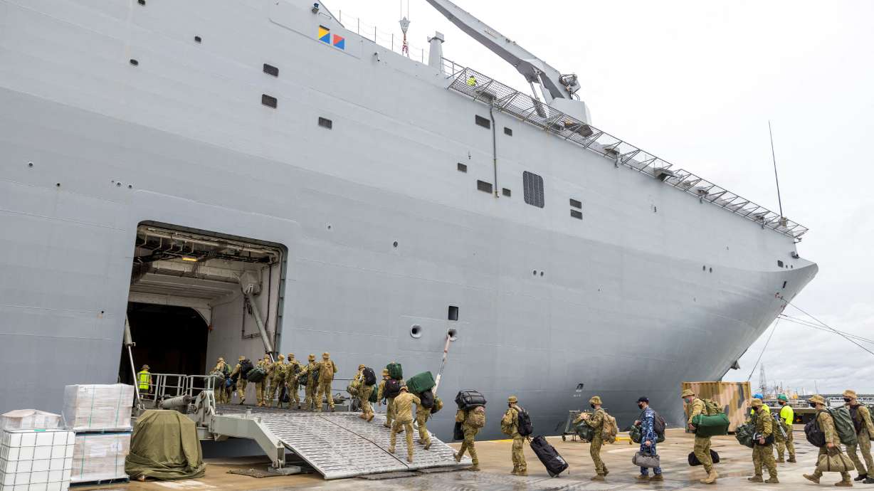 Members of the Australian Defence Force embark on HMAS Adelaide at the Port of Brisbane before departure to Tonga, in Brisbane, Australia, Thursday.