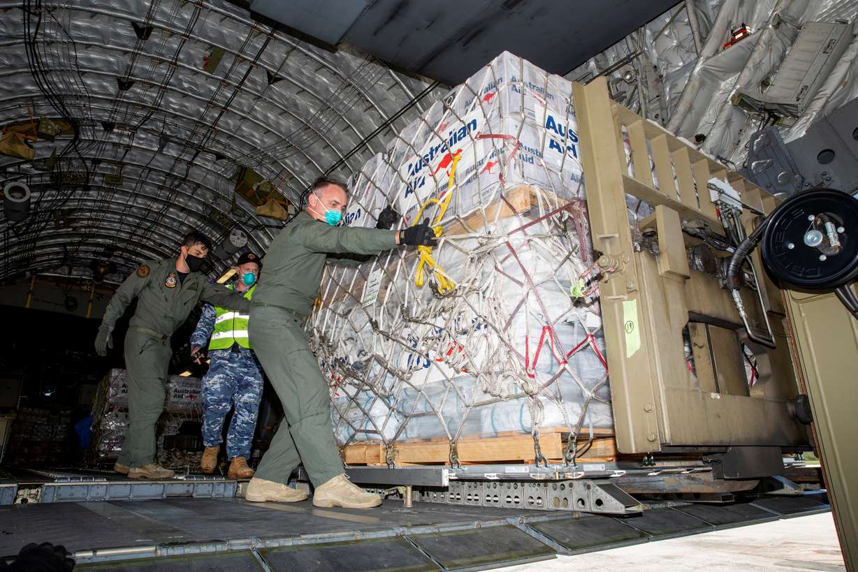 Australian Defence Forces members unload humanitarian assistance and engineering equipment from an aircraft at Fua'amotu International Airport, Tonga, Thursday.