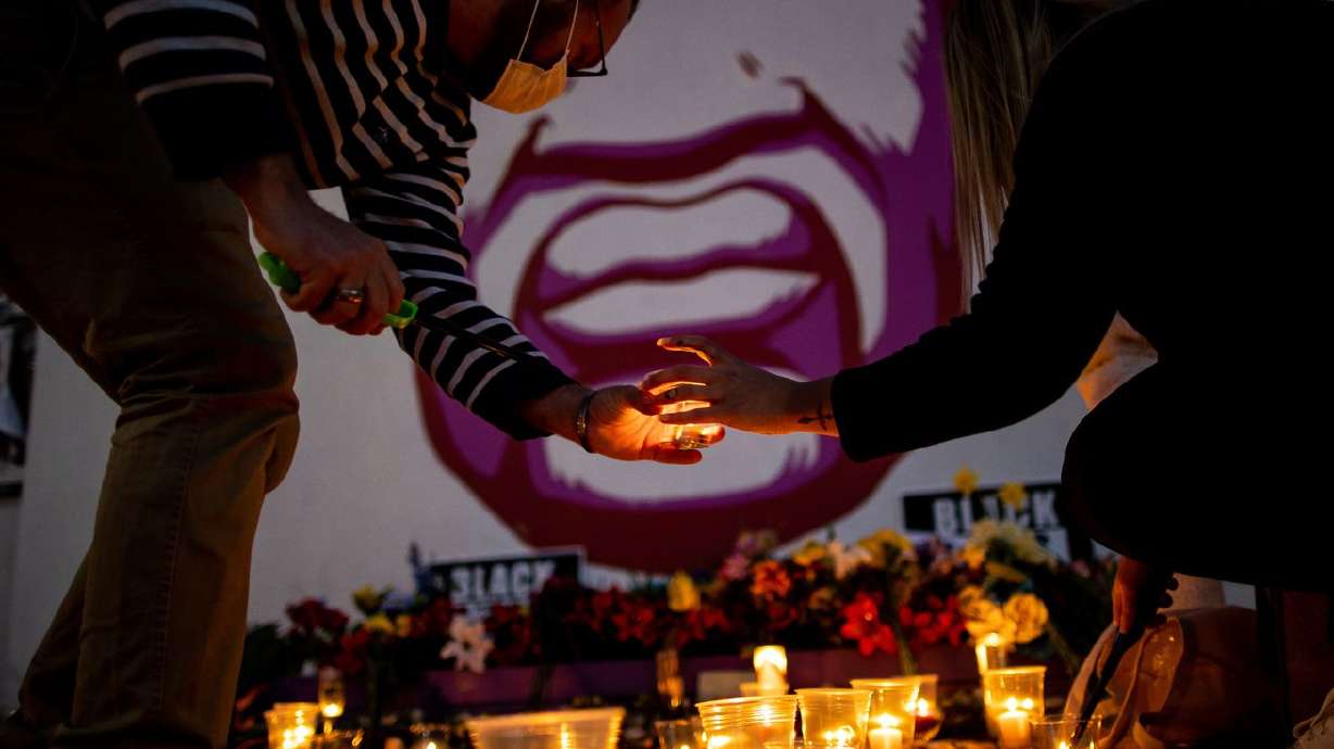 Rob Hall and Misti Western light candles in front of a
mural of George Floyd in Salt Lake City after a jury found former
Minneapolis police officer Derek Chauvin guilty in the killing of
Floyd on April 20, 2021. Floyd’s brother, Philonise Floyd spoke at
Utah Valley University on Thursday.