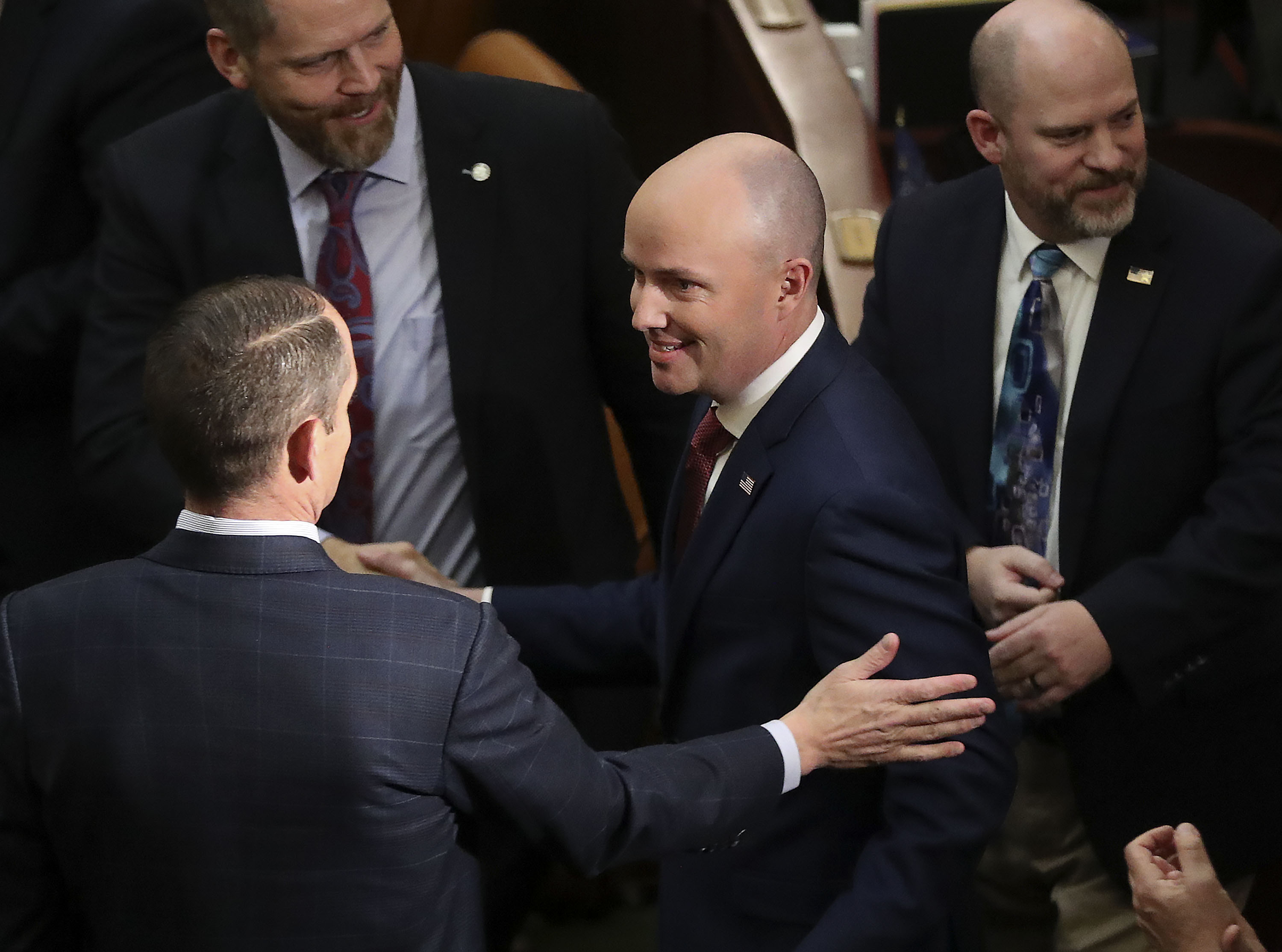 Legislators greet Gov. Spencer Cox as he enters the House of Representatives to deliver the 2022 State of the State at the Capitol in Salt Lake City on Thursday.