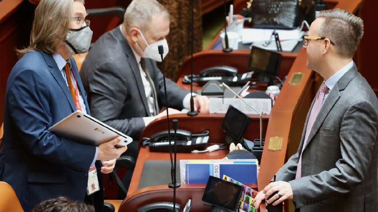 Rep. Joel Briscoe, D-Salt Lake City, talks with Rep. Brady Brammer, R-Highland, as Rep. Doug Owens, R-Millcreek, works behind them prior to the beginning of the fourth day of the
Utah legislative session Friday.
