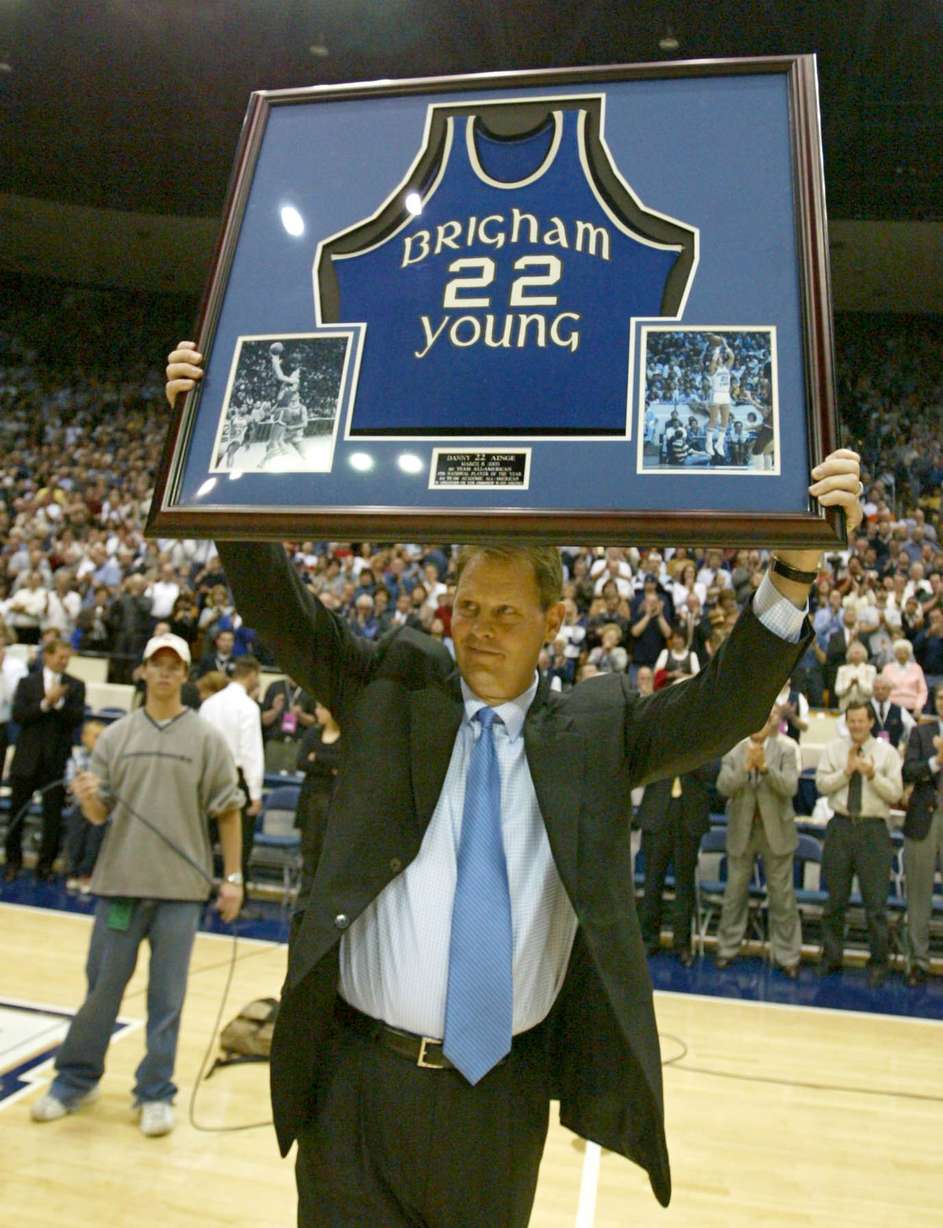 Former Brigham Young star Danny Ainge hoists his framed college jersey during a number retirement ceremony in his honor, March 8, 2003, during halftime of the BYU-Colorado State game in Provo.