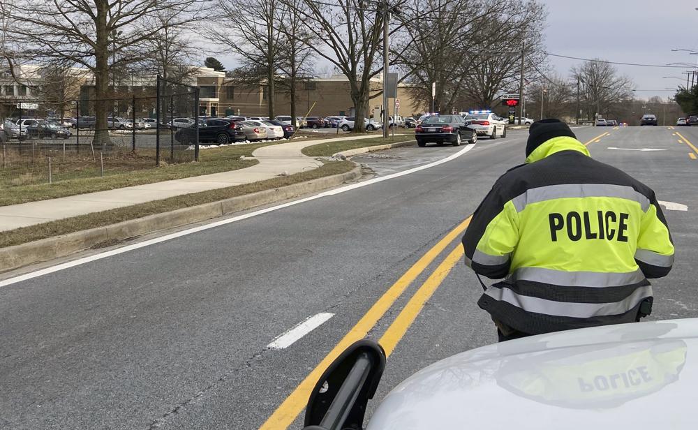 A policeman stands near the scene at Col. Zadok Magruder High School where authorities say a student was shot and a suspect was in custody, Friday, in Rockville, Md.