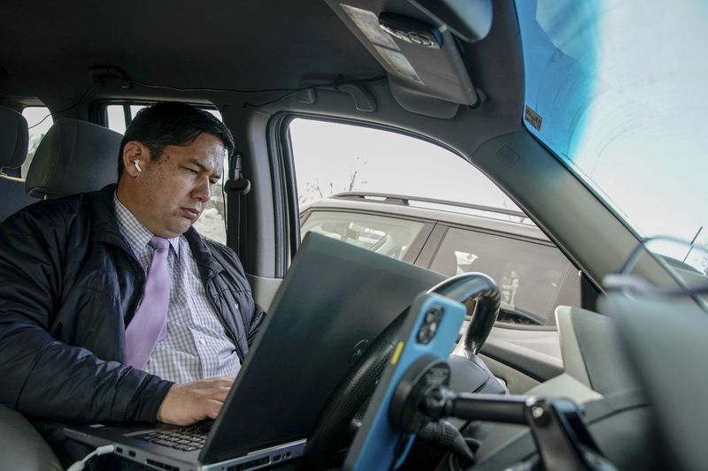 Mike Anderson, a reporter for KSL-TV, edits video clips
in his car before his live shot in Logan on Friday.