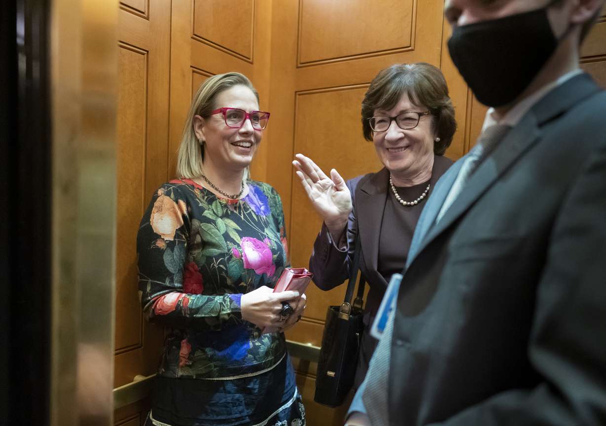 Sen. Kyrsten Sinema, D-Ariz., left, and Sen. Susan Collins, R-Maine, board the elevator outside the Senate after voting on an appropriations bill that funds the government through Feb. 18 at the Capitol in Washington, on Dec. 2, 2021.