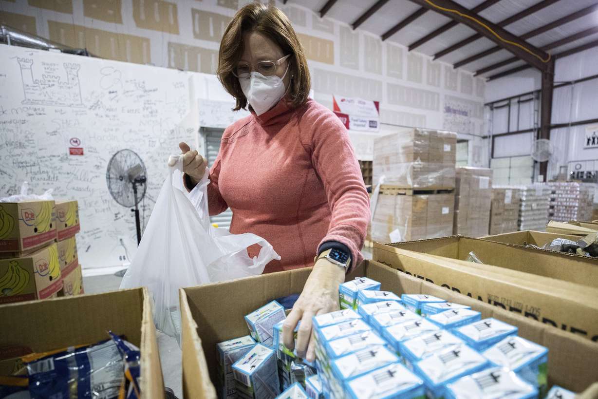 Volunteer Julia Springsteen fills a bag with food items for the backpack program at Feeding America food bank in Elizabethtown, Ky., Monday, Jan. 17, 2022. Food banks across the country are experiencing a critical shortage of volunteers as the omicron variant frightens people away from group activities.