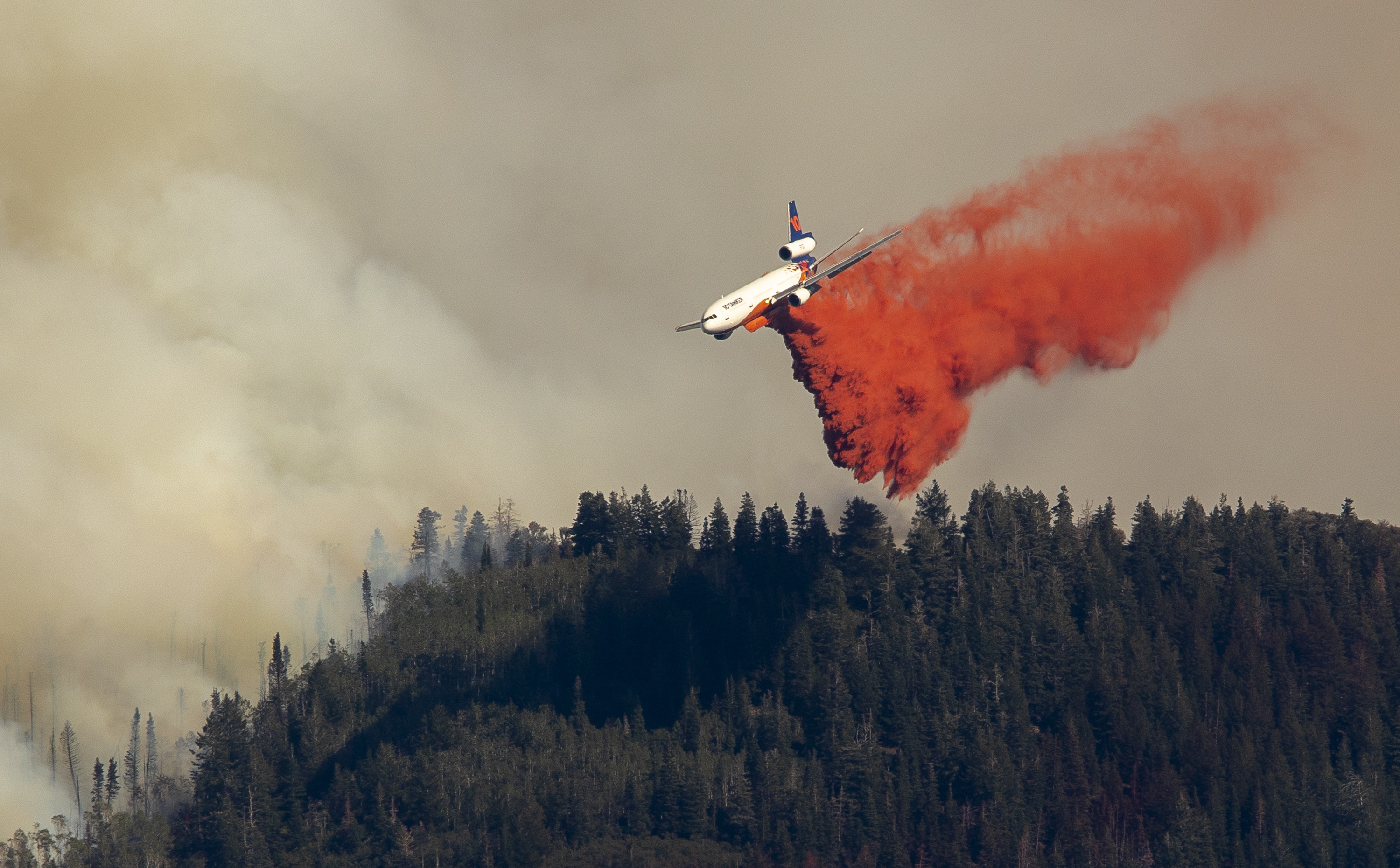 An air tanker drops retardant on the Parleys Canyon west of Park City on Saturday, Aug. 14, 2021.