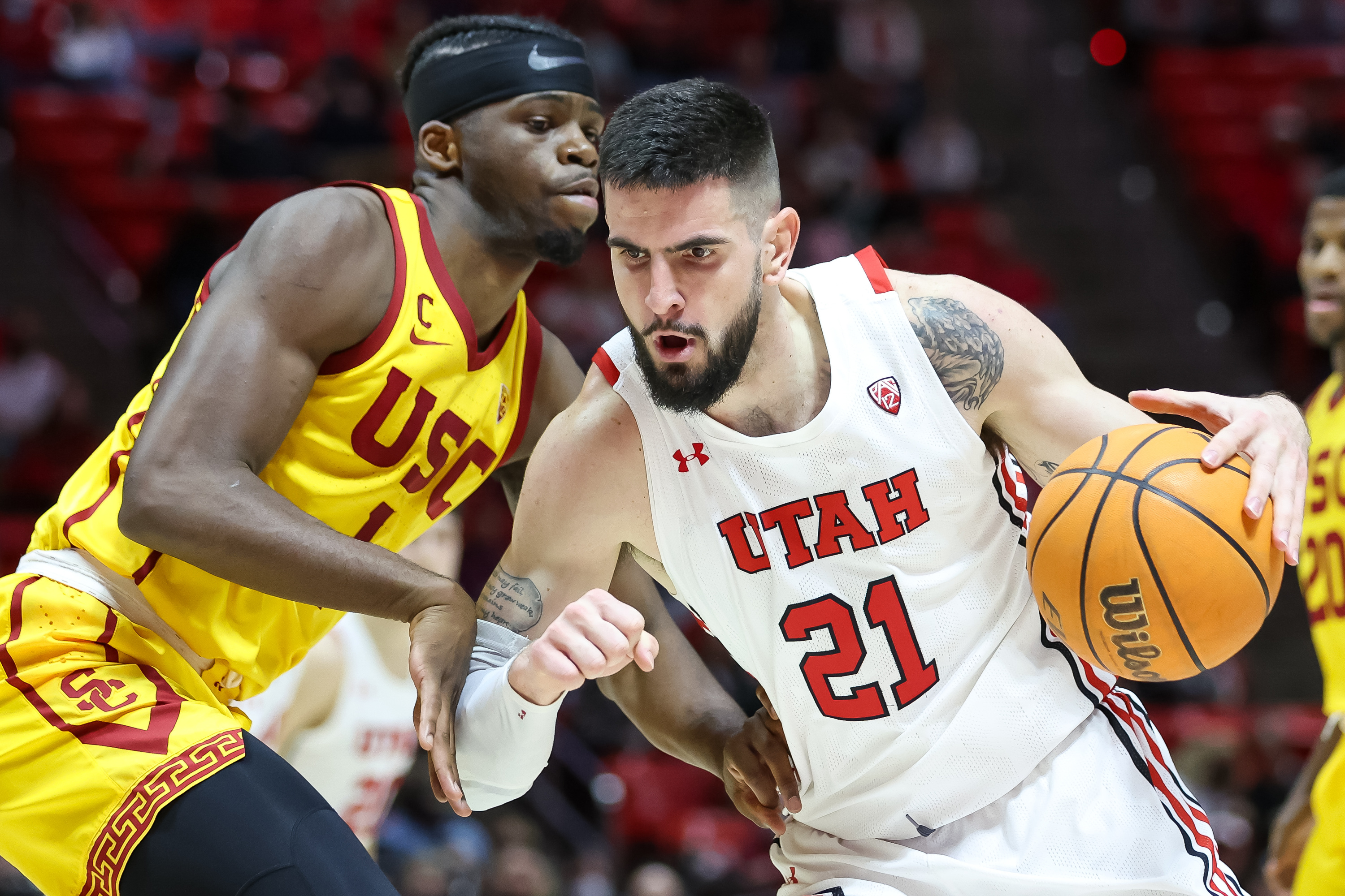 Utah Utes forward Dusan Mahorcic (21) drives into USC Trojans forward Chevez Goodwin (1) during the game at the Huntsman Center in Salt Lake City on Saturday, Jan. 22, 2022.